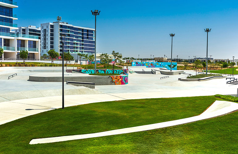 The community skate park and plaza at DAMAC Hills with apartment buildings behind